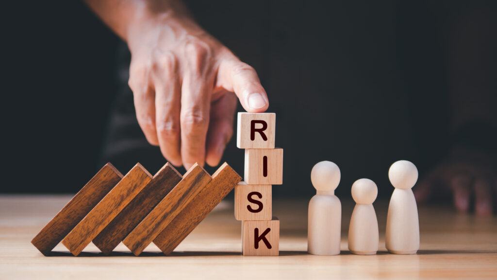 Financial Crisis, Economic, Business Risk Management Concept. Risk word on wooden block, domino effect falling to family. Concept Risk, Crisis, Management, Assessment, Insurance, Security, Finance